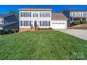 Traditional two-story home boasts a lush front lawn and inviting curb appeal at 12642 Cardinal Woods Dr, Pineville, NC 28134