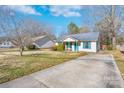 Exterior of home featuring a spacious driveway, lawn, and colorful accents against a clear blue sky at 142 Westerwood Dr, Rock Hill, SC 29732