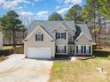 Inviting two-story home with a well-manicured lawn and attached garage at 148 Painted Bunting Dr, Troutman, NC 28166