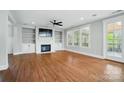 Bright living room featuring a fireplace with built-ins, hardwood floors, and a door leading to a balcony at 15307 Country Lake Dr, Pineville, NC 28134