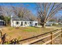 Single-story painted brick home with a well-manicured lawn and a long driveway at 1865 Woodland Dr, Charlotte, NC 28205