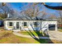 Beautiful white painted brick home with gray roof, black door and attached garage at 1865 Woodland Dr, Charlotte, NC 28205