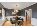 Elegant dining room with dark gray walls, crown molding, hardwood floors, and a statement chandelier at 1919 46Th Avenue Ne Dr # 46, Hickory, NC 28601