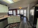 Cozy kitchen featuring a stainless steel refrigerator, white cabinets, and a windowed breakfast nook at 2234 Oak Leigh Dr, Charlotte, NC 28262