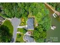 An aerial view of a waterfront home surrounded by lush trees and landscaping on Lake Norman at 228 Wildwood Cove Dr, Mooresville, NC 28117