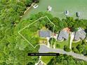 An aerial view of a lakeside home with a well-defined property line in a lush, green, wooded community at 228 Wildwood Cove Dr, Mooresville, NC 28117