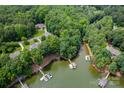 Stunning aerial view of waterfront homes with docks, surrounded by lush trees and serene waters at 228 Wildwood Cove Dr, Mooresville, NC 28117