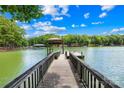The dock featuring a wooden walkway that leads to the lake and a covered boat slip at 228 Wildwood Cove Dr, Mooresville, NC 28117