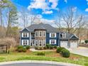 Beautiful two-story home with a well-manicured lawn, stone accents, a three-car garage, and a charming entryway at 228 Wildwood Cove Dr, Mooresville, NC 28117