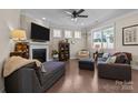 Bright living room with a fireplace, hardwood floors, and abundant natural light from large windows at 4288 Legacy Dr, Denver, NC 28037