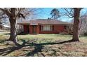Traditional brick home featuring mature trees and a cozy front porch at 4774 E Nc 150 Hwy, Lincolnton, NC 28092