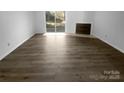 Bright living room featuring wood-look floors, a fireplace and large sliding glass door with a backyard view at 6108 Heath Ridge Ct, Charlotte, NC 28210