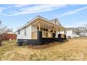 Side view of a traditional home featuring a covered porch with natural wood posts and a simple landscape at 612 Miller St, Kannapolis, NC 28081