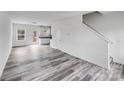 Open-concept living room with modern flooring, leading to the kitchen and staircase at 613 N Pink St, Cherryville, NC 28021