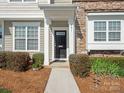 Charming townhouse entrance with a stylish black door and manicured landscaping at 831 Lacebark Dr, Rock Hill, SC 29732