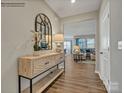 Inviting hallway with wood-look floors, decorative mirror, console table, and an open view into the living room at 8422 Norman Forest Rd, Lancaster, SC 29720