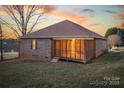 Backyard featuring a screened porch, brick exterior, and grassy yard with mature trees at 924 41St Avenue Ne Dr, Hickory, NC 28601