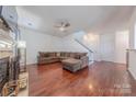Spacious living room boasting hardwood floors, a cozy fireplace, and an open staircase at 9566 Turning Wheel Dr, Charlotte, NC 28214