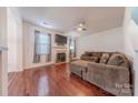 Comfortable living room featuring hardwood floors, a fireplace, and large windows that provide natural light at 9566 Turning Wheel Dr, Charlotte, NC 28214