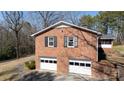 Spacious two-car garage with brick exterior and black shutters, perfect for vehicle storage at 118 Sunset Dr, Chester, SC 29706