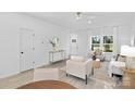 Bright and airy living room with modern decor, light wood floors, and large windows at 13110 Blacksmith Ct, Matthews, NC 28105