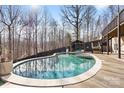 Backyard pool with a cabana and a wooden fence surrounded by mature trees creating a private backyard retreat at 153 Byers Rd, Troutman, NC 28166