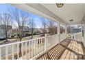 Inviting porch with wood flooring and white railing overlooking a residential street at 19531 Deer Valley Dr, Cornelius, NC 28031