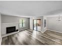 Bright living room with fireplace, vinyl floors, and sliding glass doors to the outdoor deck, creating a welcoming space at 2507 Kilborne Dr # H, Charlotte, NC 28205