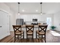 Bright kitchen featuring white cabinets, granite countertops, and stainless steel appliances with a breakfast bar at 320 Heritage Pl, Mooresville, NC 28115