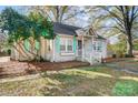 Charming bungalow with painted brick, a cozy front porch, and delightful, light-colored, mint-green shutters at 3800 Craig Ave, Charlotte, NC 28211