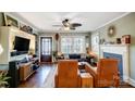 Inviting living room featuring hardwood floors, a ceiling fan, a decorative fireplace, and light, neutral paint at 3800 Craig Ave, Charlotte, NC 28211