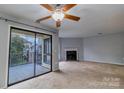 Bright living room featuring a fireplace and sliding door access to balcony at 4814 Spring Lake E Dr, Charlotte, NC 28212