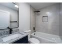 Bathroom featuring gray tile, black hardware, and a tub with shower at 527 Crowell Ave, Statesville, NC 28677