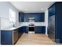 Modern kitchen featuring navy cabinets, stainless steel appliances, and granite countertops at 527 Crowell Ave, Statesville, NC 28677