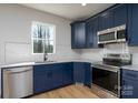 Stylish kitchen with navy cabinets, stainless steel appliances, and a view from the window at 527 Crowell Ave, Statesville, NC 28677
