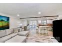 Open concept living space with seating, a bar, and access to the screened in porch at 5304 Split Oak Dr, Charlotte, NC 28227