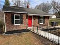 Charming brick home featuring a bright red front door, black shutters and landscaped front at 621 E Sharpe St, Statesville, NC 28677