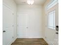 Bright foyer with wood flooring, white walls, a glass paneled front door, and two storage closets at 7216 Hodges Meadow Ln, Charlotte, NC 28213