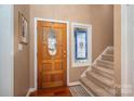 Inviting entryway with stained glass window, beautiful wooden door and staircase at 8082 Golf Course N Dr, Denver, NC 28037