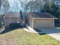 Well-maintained exterior with attached garage and ramp, nestled in a wooded setting at 8082 Golf Course N Dr, Denver, NC 28037