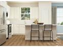 Bright, modern kitchen featuring white cabinets, stainless steel appliances, a center island, and hardwood floors at 8426 Norman Forest Rd, Lancaster, SC 29720