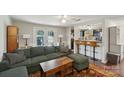 Open-concept living room featuring a sofa, counter seating, and access to the outdoor patio at 8432 Othello Pl, Charlotte, NC 28227