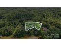 A scenic aerial view showcases a wooded lot with mature trees, providing privacy and a natural setting at 000A Duck Cove Rd, Belmont, NC 28012