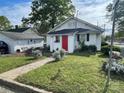 Charming home featuring a vibrant red front door, white siding, and well-maintained lawn, creating a welcoming curb appeal at 1001 N Cannon Blvd, Kannapolis, NC 28083