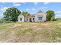 Charming white farmhouse featuring a welcoming front porch and black front door with a well-manicured lawn at 1037 Dameron Rd, Bessemer City, NC 28016