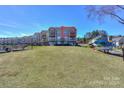 View of the condo building from the lawn, showing the balcony and lake access with boat storage at 107 Pier 33 Dr # 103, Mooresville, NC 28117