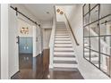 Welcoming entryway with dark wood floors, staircase, and a sliding barn door leading to an adjacent room at 107 W Poindexter Dr, Charlotte, NC 28203