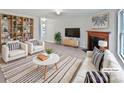 Cozy living room featuring a fireplace, modern furniture and bright, neutral colors at 1121 Swearngan Ridge Ct, Charlotte, NC 28216