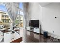 Contemporary living room with hardwood floors, floor-to-ceiling windows, and a large flatscreen television at 1133 Metropolitan Ave # 318, Charlotte, NC 28204