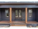 Inviting front entrance with decorative glass door, wood columns, and clear house number signage at 123 Mills Garden Rd, Statesville, NC 28625